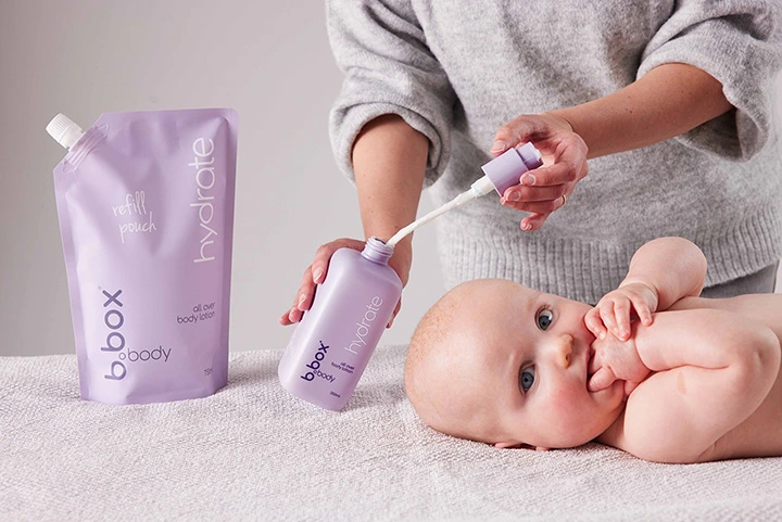 A mother refilling the hydrate, all-over body lotion, bottle using the refill pouch